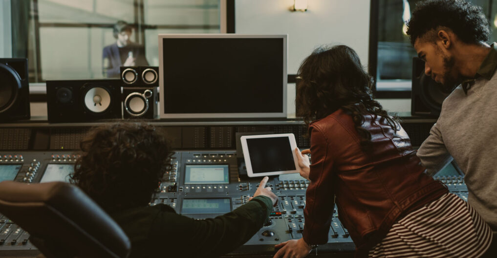 sound producers using tablet together at recording studio sound producers using tablet together at recording studio